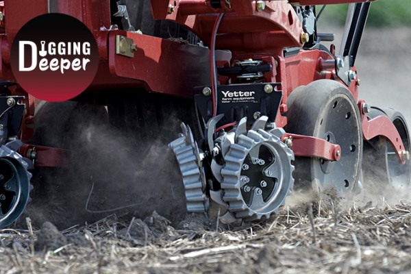 Closeup of Yetter Short Floating Row Cleaners on red planter running in field with Digging Deeper logo